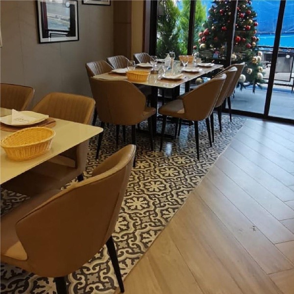 Dining tables and chairs standing on the patterned cement tile floor at Kababji Fuhais